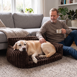 Senior Labrador resting its chin on the armrest of the HuddleHaven bed next to its owner